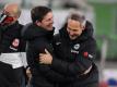 Wolfsburgs Trainer Oliver Glasner (M) und Frankfurts Trainer Adi Hütter (r) begrüßen sich vor einem Spiel. Foto: Swen Pförtner/dpa/Archivbild