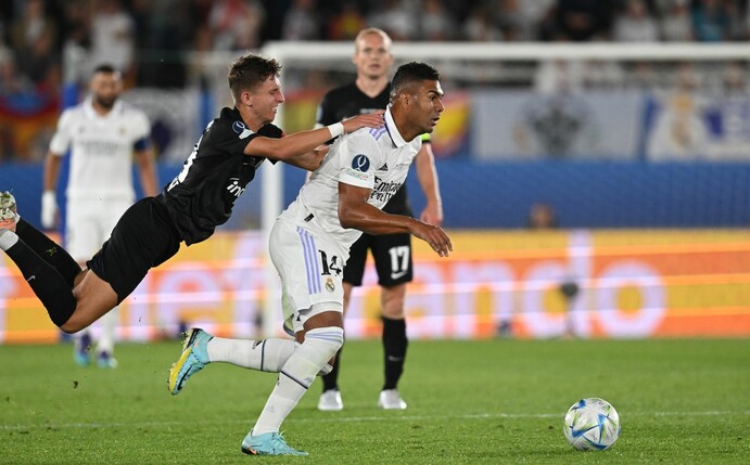 Frankfurts Jesper Lindström (l) versucht im Zweikampf Madrids Casemiro vom Ball zu trennen.