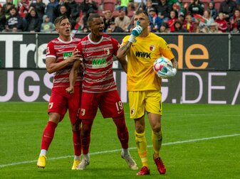 Augsburgs Torwart Rafal Gikiewicz (r) lässt sich nach dem gehaltenen Elfmeter von Emirdan Demirovic (l) und Felix Uduokhai feiern. Augsburgs Torwart Rafal Gikiewicz (r) lässt sich nach dem gehaltenen Elfmeter von Emirdan Demirovic (l) und Felix Uduokhai feiern.