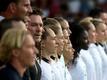 Bundestrainerin Martina Voss-Tecklenburg und die deutschen Spielerinnen singen bei der EM die Nationalhymne.