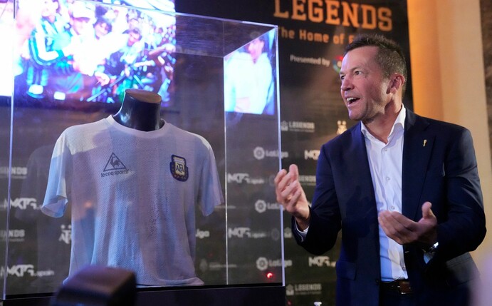 Lothar Matthäus neben einer Vitrine, in der sich das Trikot von Diego Maradona befindet.