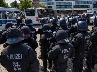 Polizisten sichern die Anreise von Fußballfans eines gegnerischen Vereins. Polizisten sichern die Anreise von Fußballfans eines gegnerischen Vereins.