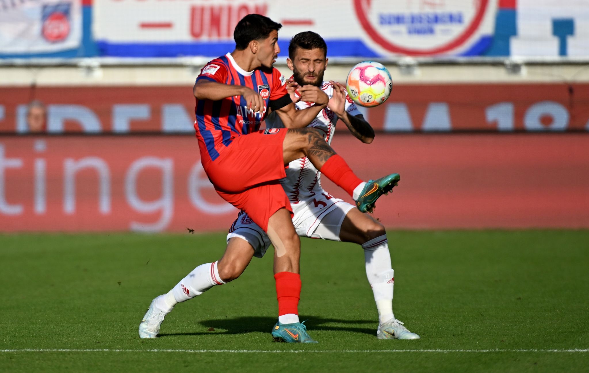 Heidenheims Kevin Sessa (l) und Düsseldorfs Nicolas Gavory kämpfen um den Ball.