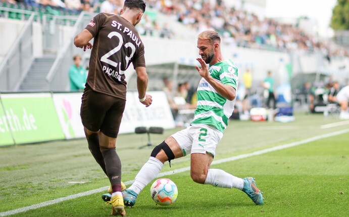 Der Fürther Simon Asta (r) im Zweikampf mit Leart Paqarada vom FC St. Pauli.
