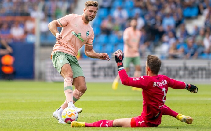 Bremens Niclas Füllkrug (l) im Angriff gegen Bochums Torhüter Manuel Riemann.