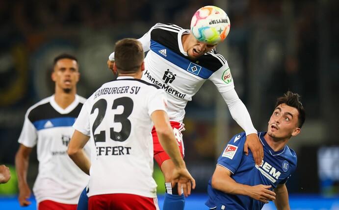 Hamburgs Ludovit Reis setzt sich im Kopfballduell gegen Karlsruhes Paul Nebel (r) durch.