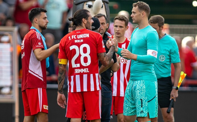 Union-Kapitän Christopher Trimmel (M.) klatscht sich nach dem Spiel mit Bayern-Torwart Manuel Neuer ab.