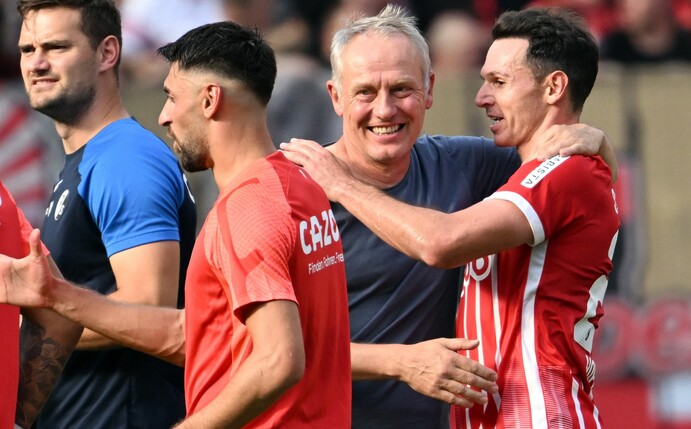 Freiburgs Trainer Christian Streich (l) freut sich mit seinen Spielern nach dem Sieg in Leverkusen.