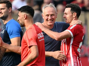 Freiburgs Trainer Christian Streich (l) freut sich mit seinen Spielern nach dem Sieg in Leverkusen. Freiburgs Trainer Christian Streich (l) freut sich mit seinen Spielern nach dem Sieg in Leverkusen.