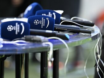 Mikrofone mit dem Logo der Champions League liegen vor einem Spiel auf einem Tisch. Mikrofone mit dem Logo der Champions League liegen vor einem Spiel auf einem Tisch.