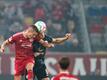 Düsseldorfs Kristoffer Petersen (l) und Dennis Dressel von Hansa Rostock kämpfen um den Ball.