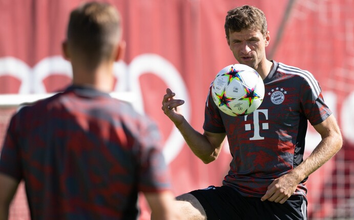 Bayerns Thomas Müller (r) und Joshua Kimmich halten im Training den Ball hoch.