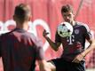 Bayerns Thomas Müller (r) und Joshua Kimmich halten im Training den Ball hoch.