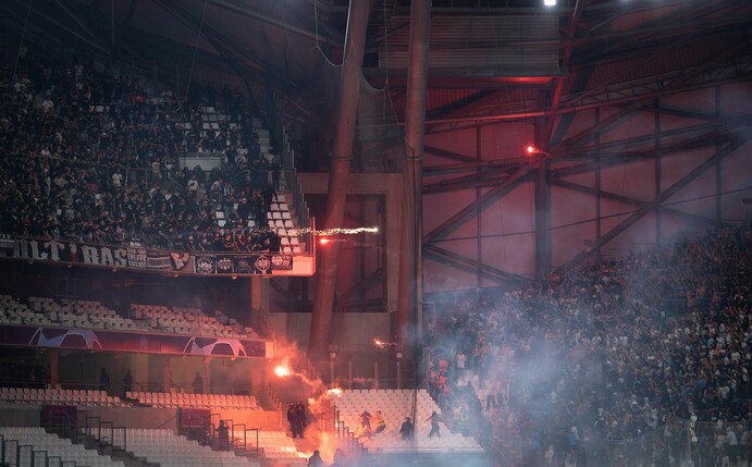 die Blöcke der Ultras der Eintracht (l) und von Marseille beschießen sich mit Feuerwerk.