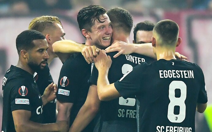 Die Spieler des SC Freiburg feiern den Sieg bei Olympiakos Piräus.