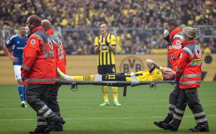 Dortmunds Marco Reus wird verletzt vom Platz getragen.