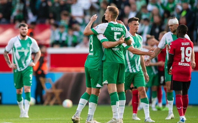Bremens Milos Veljkovic (l) und Amos Pieper umarmen sich nach der Partie.