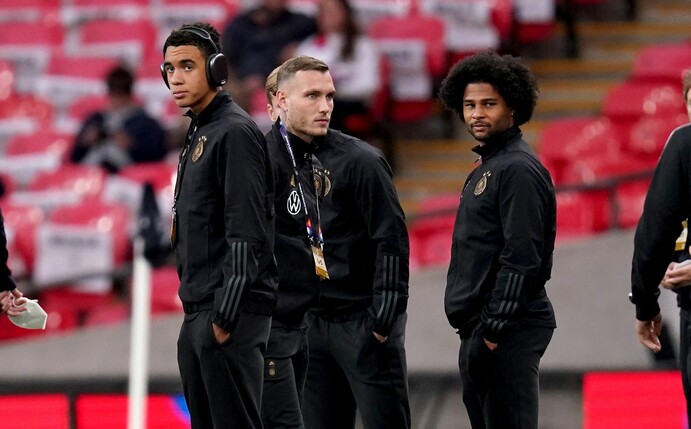 Die deutschen Nationalspieler Jamal Musiala (l-r), David Raum und Serge Gnabry schauen sich vor dem Spiel im Stadion um.
