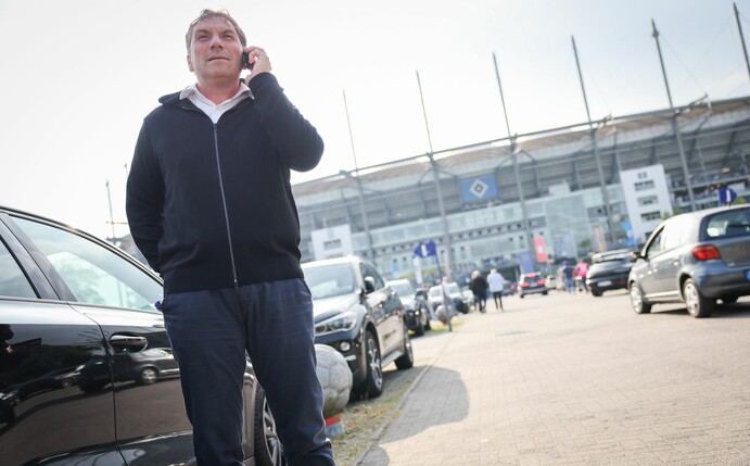 Thomas Wüstefeld, Noch-Vorstand des Hamburger SV, telefoniert vor einem Spiel auf dem Parkplatz vor dem Stadion.
