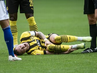 Dortmunds Marco Reus liegt während des Revierderbys verletzt am Boden. Dortmunds Marco Reus liegt während des Revierderbys verletzt am Boden.