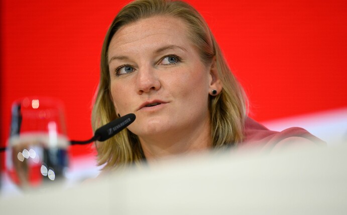 Nationalspielerin Alexandra Popp sitzt während einer Pressekonferenz auf dem Podium.