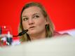 Nationalspielerin Alexandra Popp sitzt während einer Pressekonferenz auf dem Podium.