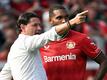 Leverkusens Trainer Gerardo Seoane (l) spricht an der Seitenlinie mit Jonathan Tah.