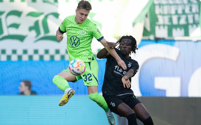 Wolfsburgs Mattias Svanberg (l) spielt im Zweikampf mit Gladbachs Manu Kone.