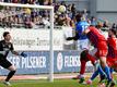 Kiels Kwasi Wriedt (M) kommt gegen Heidenheims Torwart Kevin Müller (l) zum Kopfball.