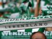 Werder Fans halten ihre Schals hoch.