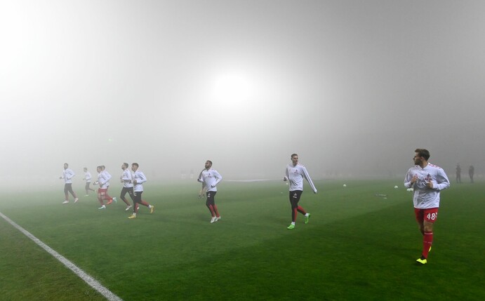 Die Kölner Spieler wärmen sich im dichten Nebel vor dem Spielabbruch auf.