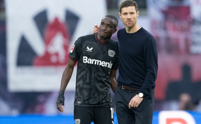 Leverkusens Moussa Diaby (l) und Bayer-Trainer Xabi Alonso stehen nach der Niederlage in Leipzig auf dem Rasen.