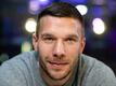 Der frühere Fußball-Nationalspieler Lukas Podolski lächelt in die Kamera.