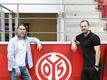 Mainz-Trainer Bo Svensson (r) steht neben Sportdirektor Martin Schmidt neben einem Logo des Vereins.