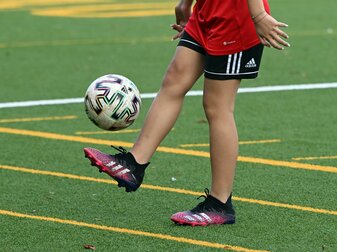 Ein Mädchen jongliert auf dem Fußballplatz der Ostkampfbahn in Köln. Ein Mädchen jongliert auf dem Fußballplatz der Ostkampfbahn in Köln.