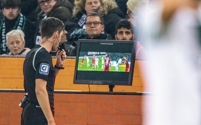 Schiedsrichter Matthias Jöllenbeck prüft per Videobeweis.
