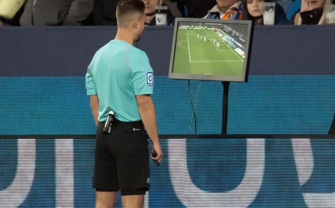 Schiedsrichter Daniel Schlager schaut sich eine Szene auf einem Monitor an und gibt anschliessend einen Gladbacher Treffer nicht.