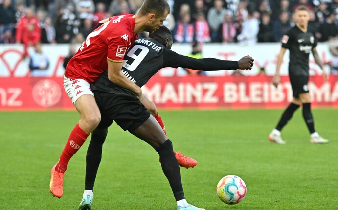 Frankfurts Torschütze Randal Kolo Muani (r) im Zweikampf mit dem Mainzer Alexander Hack.
