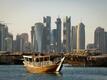 Dhow-Boote, wie sie früher die Perlentaucher genutzt haben, fahren mit Touristen im Meer vor der Skyline von Doha.