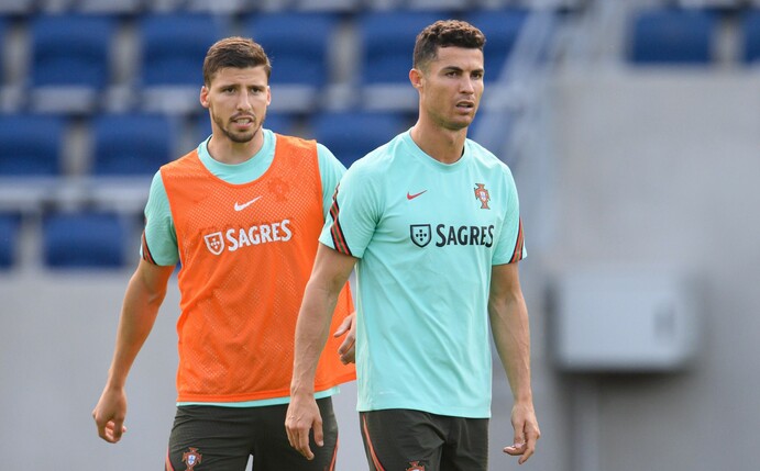 Portugals Cristiano Ronaldo (r) und Ruben Dias stehen während des Trainings nebeneinander.