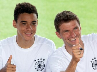 Deutschlands Jamal Musiala (l) und Thomas Müller grüßen Fans während einer Autogrammstunde. Deutschlands Jamal Musiala (l) und Thomas Müller grüßen Fans während einer Autogrammstunde.