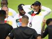 Kameruns Cheftrainer Rigobert Song (r) steht mit der Nationalmannschaft auf dem Trainingsplatz.