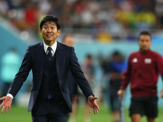 Japans Trainer Hajime Moriyasu breitet zum Spielende lachend die Arme aus. Japans Trainer Hajime Moriyasu breitet zum Spielende lachend die Arme aus.