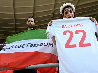 Iraner protestieren vor dem Spiel gegen Wales mit einer Fahne ohne die Symbole der islamischen Republik, dafür mit der Aufschrift «Women Life Freedom». Iraner protestieren vor dem Spiel gegen Wales mit einer Fahne ohne die Symbole der islamischen Republik, dafür mit der Aufschrift «Women Life Freedom».