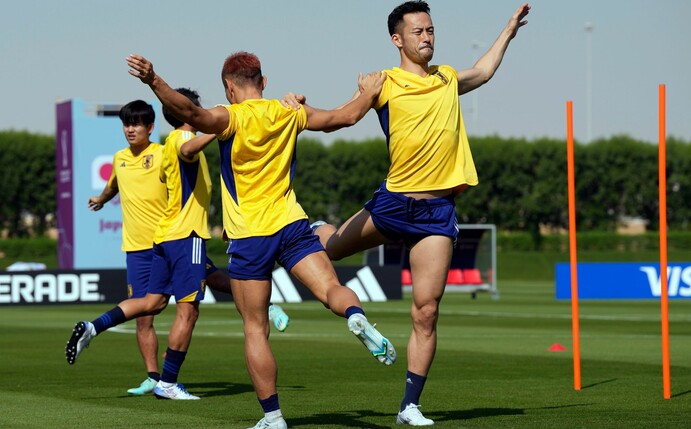 Japans Maya Yoshida (r) und Yuto Nagatomo wärmen sich mit ihren Mannschaftskameraden auf.