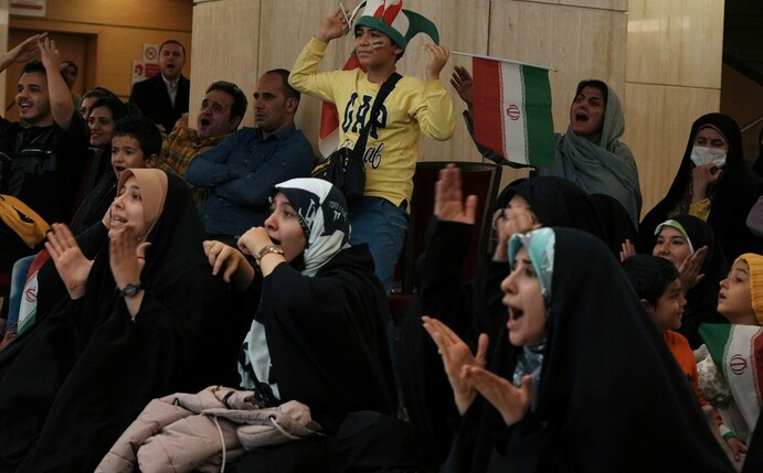Iranische Fans verfolgen das Spiel gegen USA auf einem Großbildschirm in einem Kulturzentrum in Teheran.