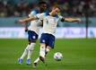 Englands Harry Kane spielt den Ball, dahinter Bukayo Saka.