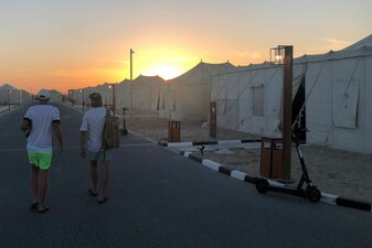 Zwei deutsche Fußballfans laufen durch das Fan-Dorf in Al-Chaur im Norden von Katar. Zwei deutsche Fußballfans laufen durch das Fan-Dorf in Al-Chaur im Norden von Katar.