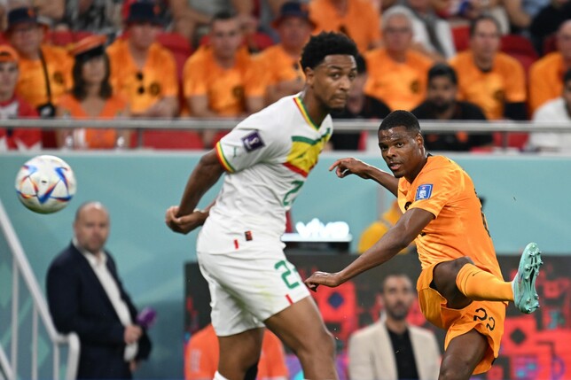 Der Niederländer Denzel Dumfries (r) schiesst den Ball an Senegals Abdou Diallo vorbei.