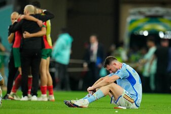 Spaniens Aymeric Laporte sitzt nach der Niederlage auf dem Spielfeld, während Marokkos Spieler im Hintergrund über ihren Sieg im Elfmeterschiessen jubeln. Spaniens Aymeric Laporte sitzt nach der Niederlage auf dem Spielfeld, während Marokkos Spieler im Hintergrund über ihren Sieg im Elfmeterschiessen jubeln.